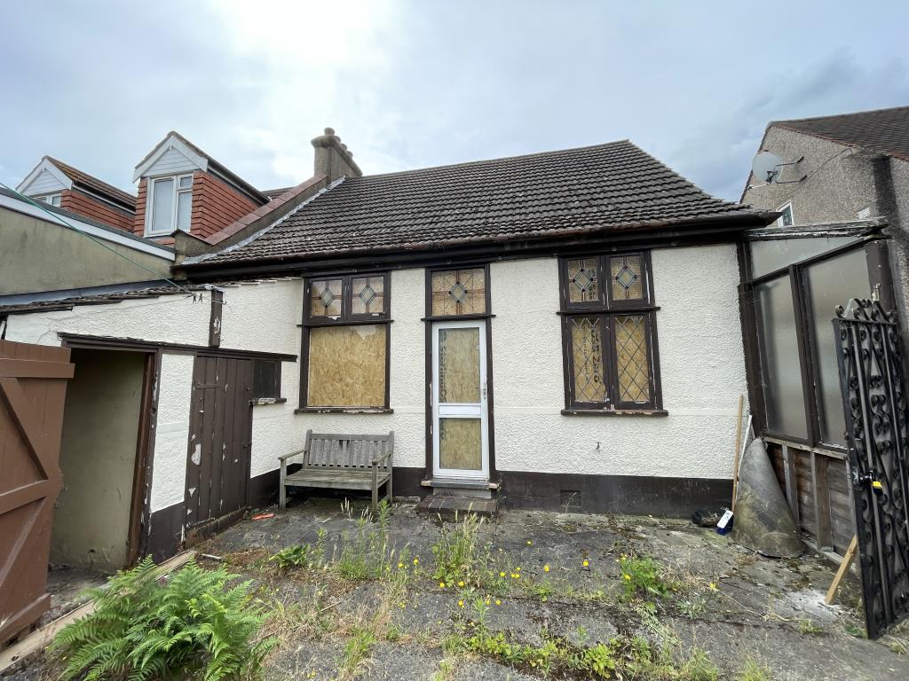 Lot: 27 - SEMI-DETACHED BUNGALOW WITH GARAGE FOR IMPROVEMENT - outside photo of the rear of the property looking from the garden